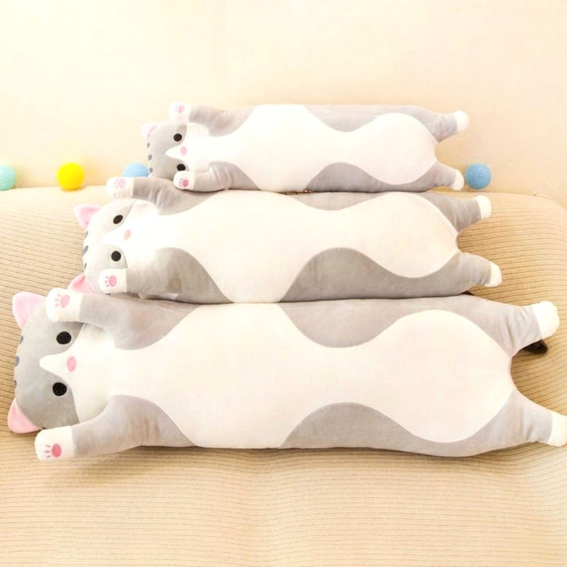 Three long gray cat plush toys of varying sizes lying on a sofa, showcasing soft fabric and huggable design, ideal as cuddle buddies or decorative plush.